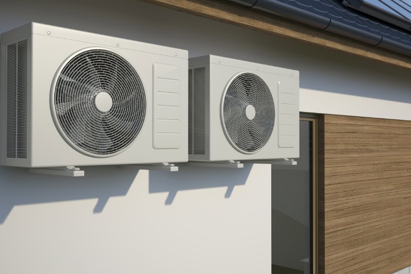 air conditioners attached to outdoor wall of building.