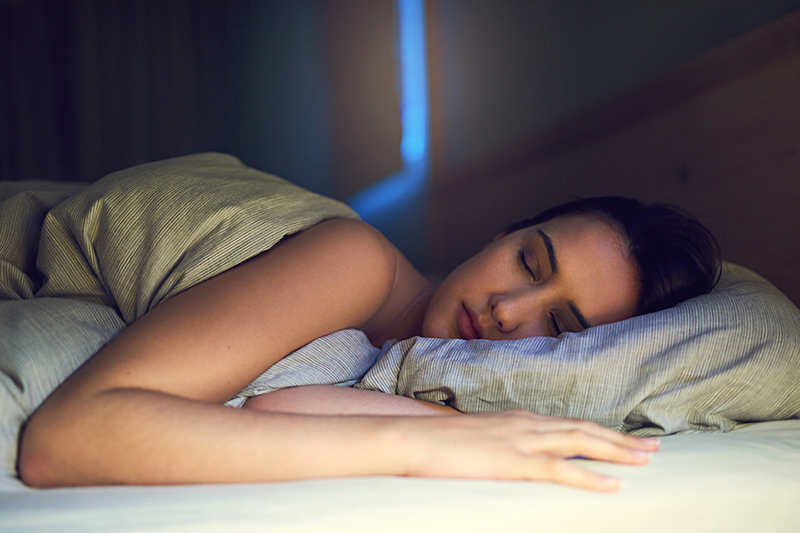Blog Title: 3 Health Benefits for Using Your AC While Sleeping Photo of a woman getting a good night sleep
