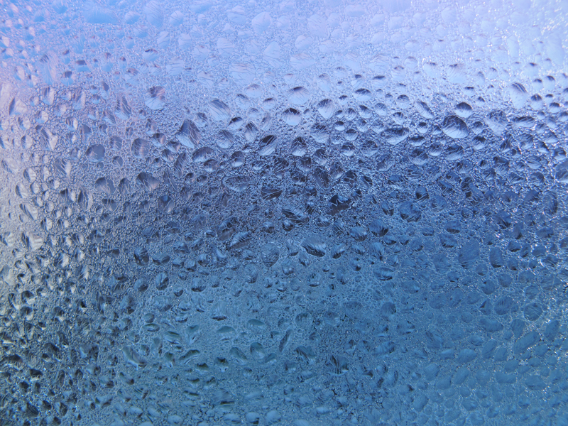 water drops and frost on window glass. close-up natural texture.