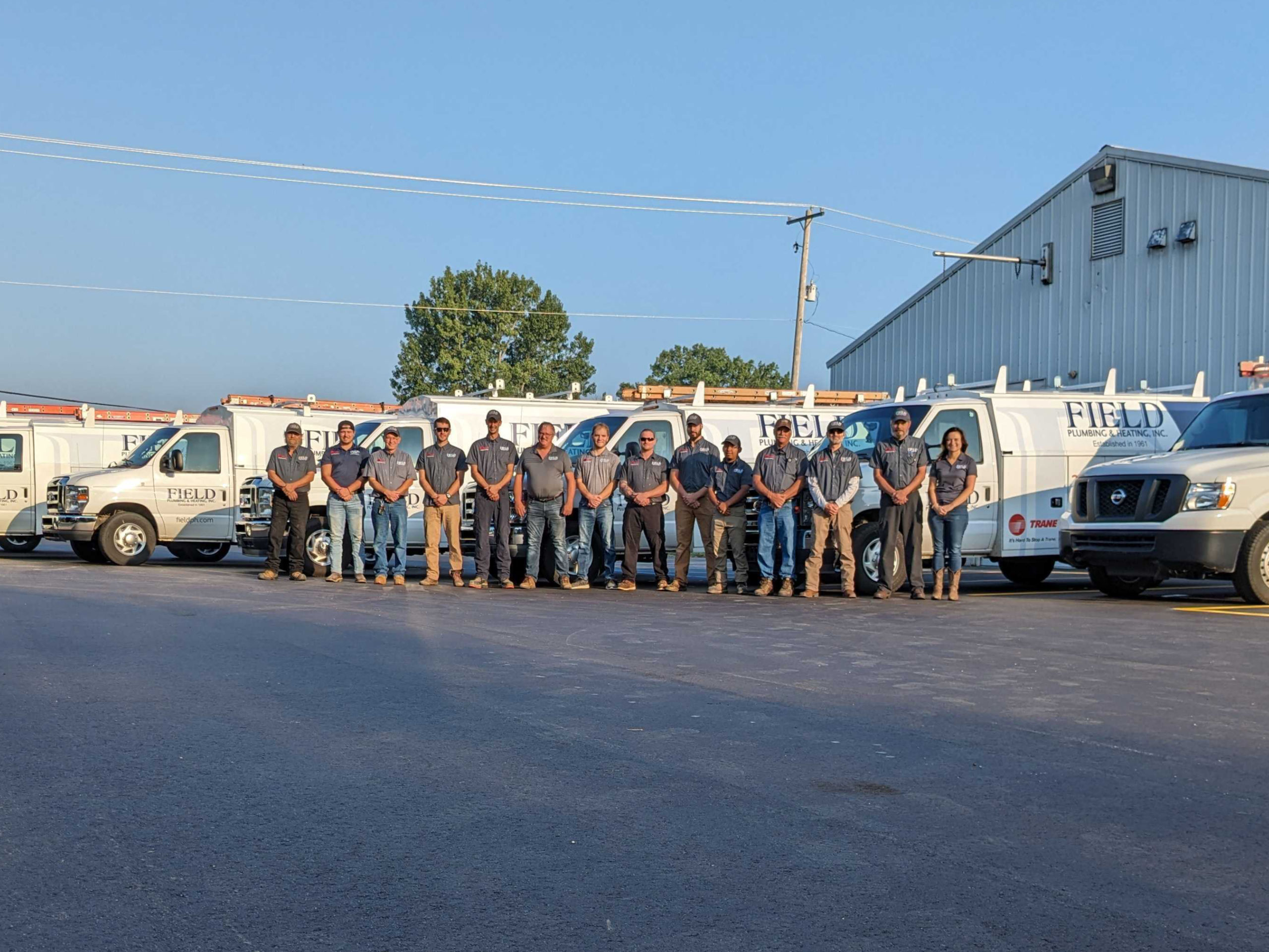 Field team standing in front of the vans.