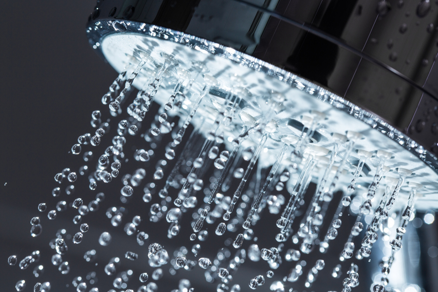 Help! I Have No Hot Water. Shower Head with Water Stream on Black Background.
