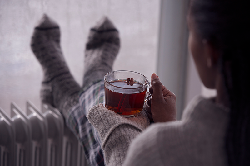 A person enjoys a drink in front of a window. How to Spot a Cracked Heat Exchanger.